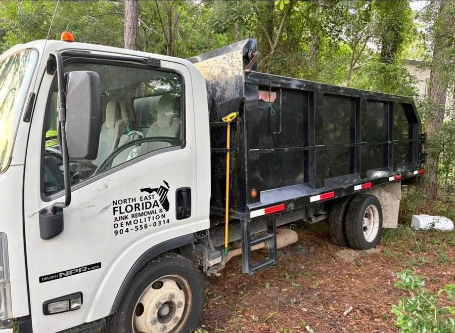 The Isuzu dump truck with the North East Florida Junk Removal decal on the door